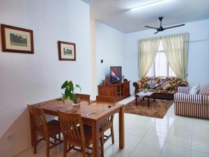 a living room with a wooden table and chairs at Ipoh - Apartment Casa Klebang 1 Fully Air-Con Suite in Chemor