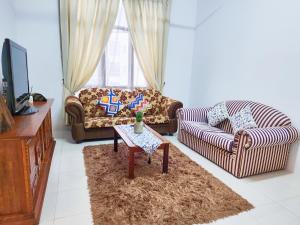a living room with two couches and a table at Ipoh - Apartment Casa Klebang 1 Fully Air-Con Suite in Chemor