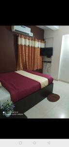 ein Schlafzimmer mit einem Bett mit einer roten Decke in der Unterkunft manjunatha residency in Chikmagalur