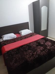 1 Schlafzimmer mit 2 Betten und roter Bettwäsche in der Unterkunft manjunatha residency in Chikmagalur