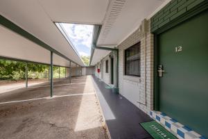 an empty hallway of a building with a green door at Everton Park Hotel in Brisbane