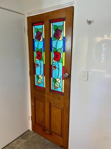 een deur met een glas-in-loodraam in een kamer bij The Art Gallery Boreen Point in Cootharaba
