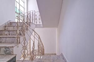 a staircase in a house with white walls at OYO Dream Square in Gwalior