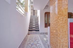 a staircase in a house with white walls and a tile floor at OYO Dream Square in Gwalior
