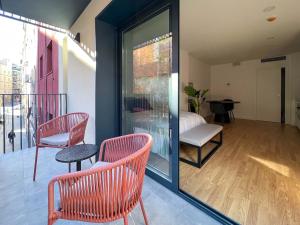 a balcony with two chairs and a table and a window at Stay U-nique Apartments Albeniz BCN in Hospitalet de Llobregat