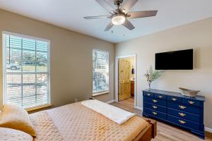 a bedroom with a bed and a ceiling fan at Sun Dappled Cottage in Spring Branch