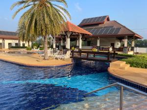 una casa con una palmera y una piscina en Seabreeze Villa, en Rayong