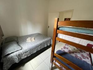 a bedroom with two bunk beds and a mirror at Casa Pelinca 1 quarto in Campos dos Goytacazes