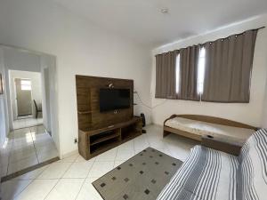 a bedroom with a bed and a television in it at Casa Pelinca 1 quarto in Campos dos Goytacazes