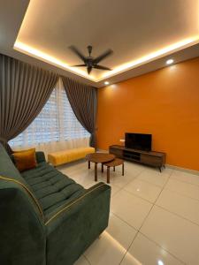 un soggiorno con divano verde e TV di Suhas House (Palmyra Residence) a Kajang