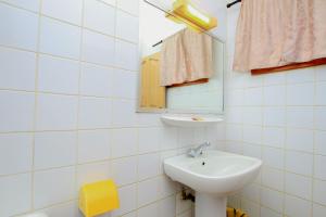 a white bathroom with a sink and a mirror at Hotel Le Prince in Cotonou