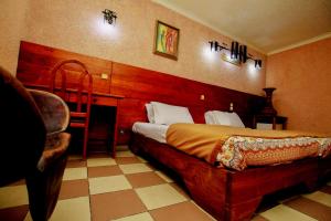 - une chambre avec un lit et une chaise dans l'établissement Hotel Le Prince, à Cotonou