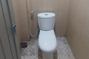 Wisma Merdeka Syariah RedPartner في باليمبانغ: حمام مع مرحاض أبيض في كشك
