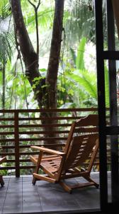 un fauteuil à bascule sur une terrasse couverte avec un arbre dans l'établissement Kapievi Ecovillage, à Puerto Maldonado