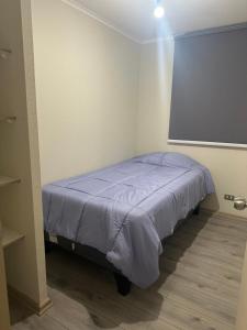 a bed in a room with a projection screen at Departamento centro Quillota con estacionamiento in Quillota