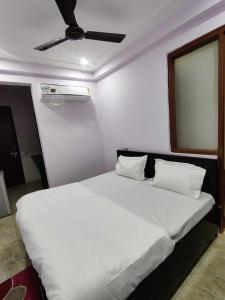 1 dormitorio con 1 cama blanca grande y techo en OYO Alpha Guest House Near Bestech Central Square Mall, en Gurgaon