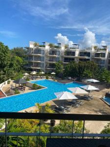 a large swimming pool with umbrellas in front of a building at Dewa One bedroom suite in Nai Yang Beach