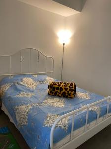 a bed with a blue comforter with a leopard pillow on it at Cozy holiday home in Toronto