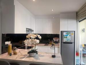 a kitchen with a table with flowers on it at Dewa One bedroom suite in Nai Yang Beach