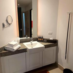 y baño con lavabo blanco y espejo. en Dewa One bedroom suite en Nai Yang Beach