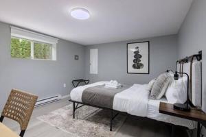 um quarto com uma cama, uma secretária e uma janela em Spacious 4 BR House in Park Drive em Vancouver