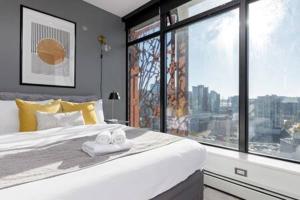 una camera da letto con un grande letto con una grande finestra di Cozy 1BR Condominium Suite in West Cordova a Vancouver