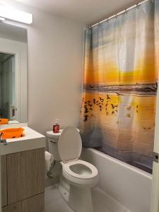 a bathroom with a toilet and a shower curtain at Cozy holiday home in Toronto