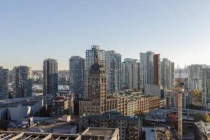 uma grande cidade com edifícios altos e uma torre do relógio em Cozy 1BR Condominium Suite in West Cordova em Vancouver