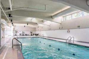 a large swimming pool with blue water in a building at Heart of Downtown Luxury 2BR Condominium in Vancouver