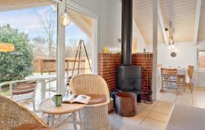 porche con chimenea, mesa y sillas en 2 Bedroom Gorgeous Home In Juelsminde, en Sønderby