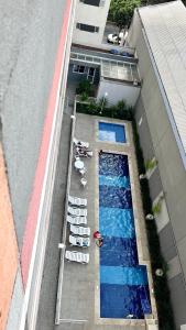 uma vista sobre uma piscina com espreguiçadeiras em Completo, moderno e bem localizado na Rua do Metrô Brás SP em São Paulo