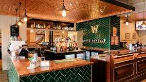 a bar in a restaurant with a green wall at Victoria Hotel Strathalbyn in Strathalbyn