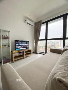 een woonkamer met een bed en een groot raam bij Urban Suites Sea & City View Apartment in Jelutong