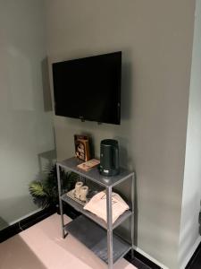 un estante con un televisor en una pared blanca en Very Hotel, en George Town