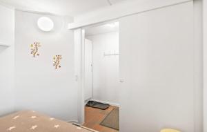 Cette chambre dispose de murs blancs et d'une porte ornée de fleurs. dans l'établissement Beautiful Apartment In Fan With Kitchen, à Fanø
