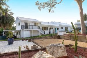a large white house with a yard with rocks at Laguna Niguel - Acreage in Tuggerah
