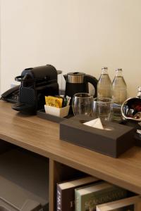 a table with a coffee maker and glasses on it at Eight Hotel Ari in Bangkok