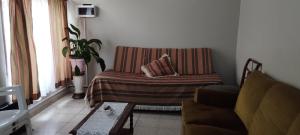 sala de estar con sofá y silla en Apartamento Alberdi en Salta en Salta