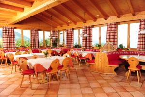 un restaurante con mesas, sillas y ventanas en Ferienhotel Samerhof, en Pfarrwerfen