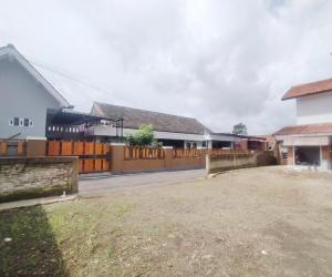 ein Haus mit einem Zaun und einem Hof in der Unterkunft RedDoorz Syariah Near Stasiun Purwokerto in Purwokerto