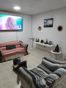 Il comprend un salon avec des canapés et une télévision à écran plat. dans l'établissement Dpto. 1er piso 4 hab.Piscina Terraza, à Punta Hermosa