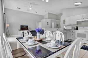 a kitchen with a dining table and white chairs at 3 Bedrooms - 2 Bathrooms - Cumbrian Lakes 4695 Cl in Orlando
