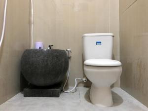 a bathroom with a toilet and a bath tub at Grand Hagawa Syariah near Alun Alun Lamongan RedPartner in Lamongan