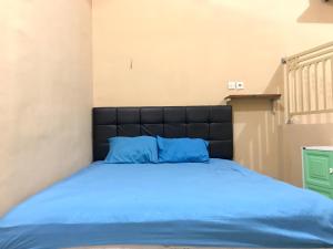 a bed with blue pillows on it in a room at Grand Hagawa Syariah near Alun Alun Lamongan RedPartner in Lamongan