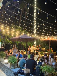 a group of people sitting in a patio at night at Top Secret Beach Hotel in Matara