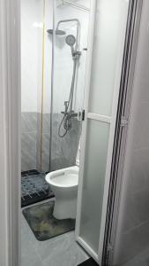 a bathroom with a toilet and a shower at Lovella Suites Gold Park in Nairobi