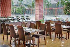 a row of tables and chairs in a restaurant at Noola Hotel Cilacap in Gumilir