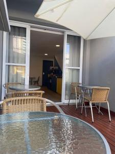 d'une terrasse avec une table et des chaises en verre, ainsi qu'une table et des chaises. dans l'établissement Mova Express Hotel - CAMPINAS, à Campinas