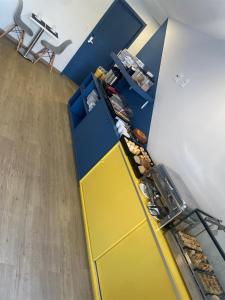 an office with a yellow and blue counter with pastries at Mova Express Hotel - CAMPINAS in Campinas