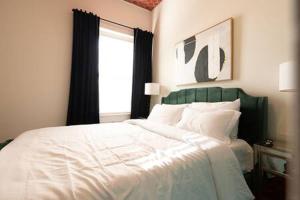 een slaapkamer met een wit bed en een raam bij Knox Vegas in Knoxville